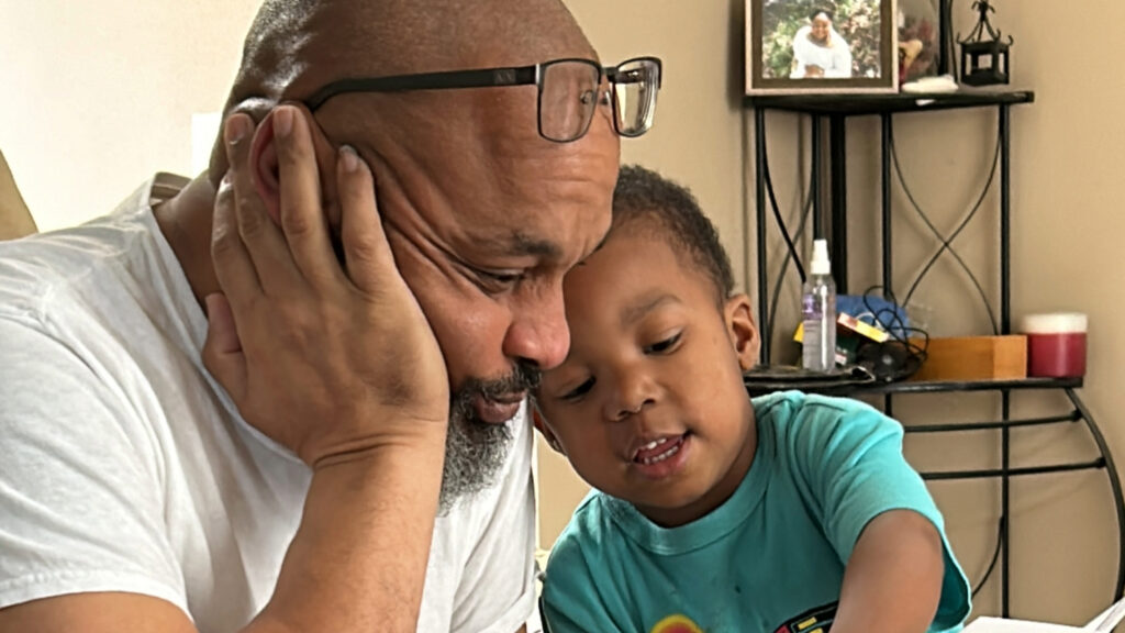 A man and a young boy looking at a card together